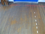 Just inside the entrance to the sports hall, it was evident that foot traffic had worn off any previously applied finish and the bare wood was showing. 