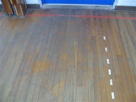 Just inside the entrance to the sports hall, it was evident that foot traffic had worn off any previously applied finish and the bare wood was showing. 
